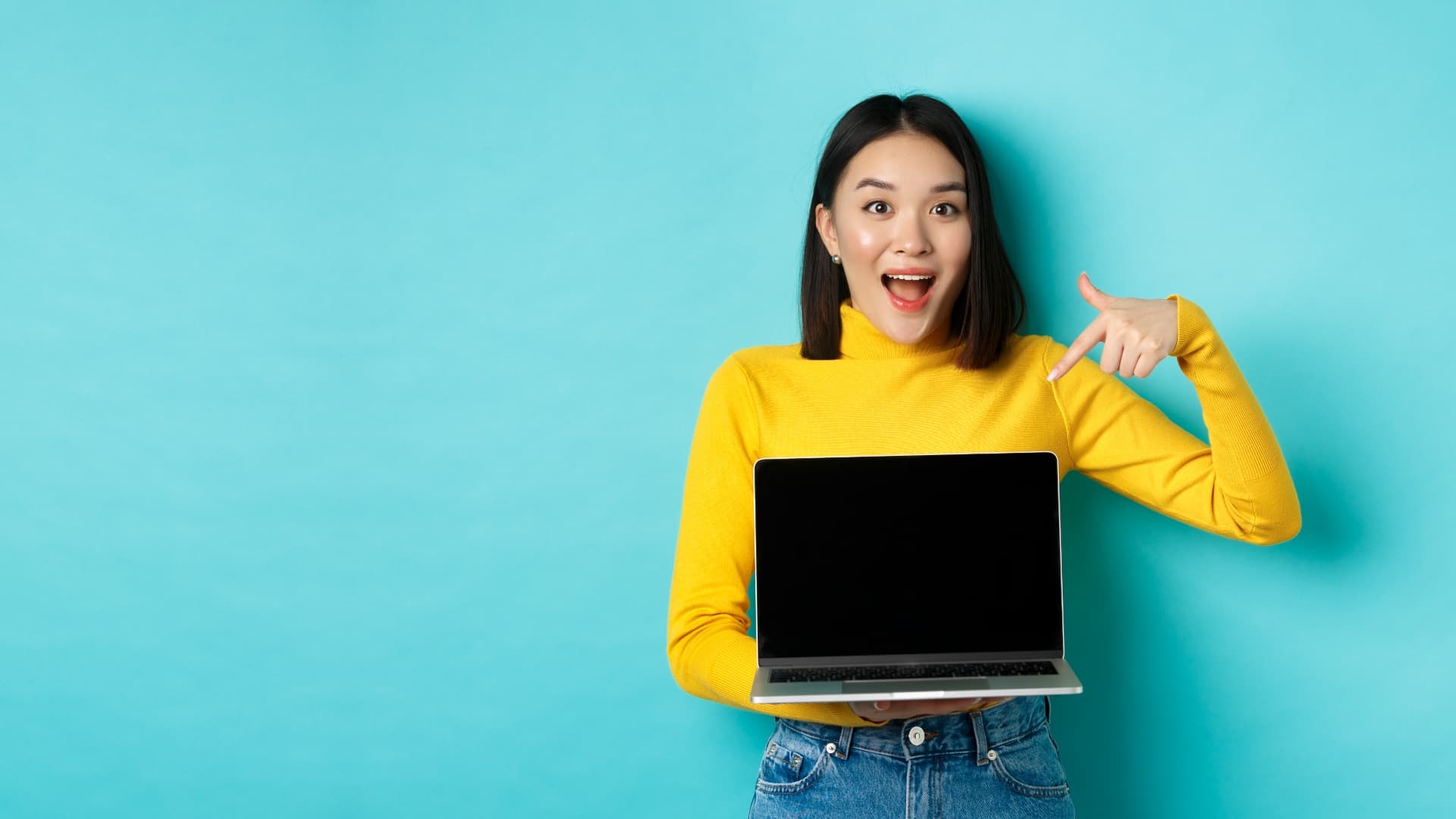 E Commerce Online Shopping Concept Excited Asian Woman Making Presentation Pointing Finger Showing Blank Laptop Screen Standing B
